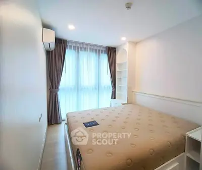 Bright and cozy bedroom with large window and modern furnishings in a stylish apartment.