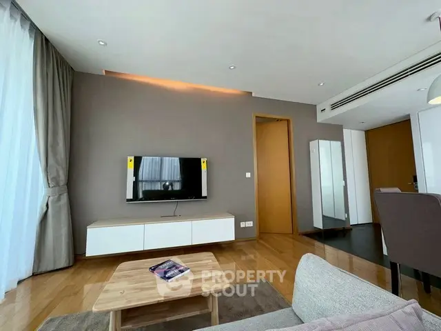 Modern living room with sleek TV setup and wooden flooring
