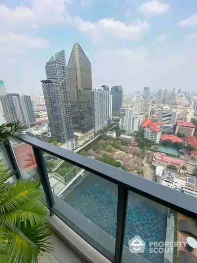 Stunning cityscape view from high-rise balcony overlooking urban skyline and pool.