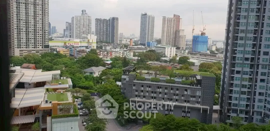 Stunning cityscape view from a high-rise apartment showcasing urban living and greenery.