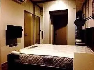 Cozy bedroom with modern design and wall-mounted TV, perfect for relaxation.