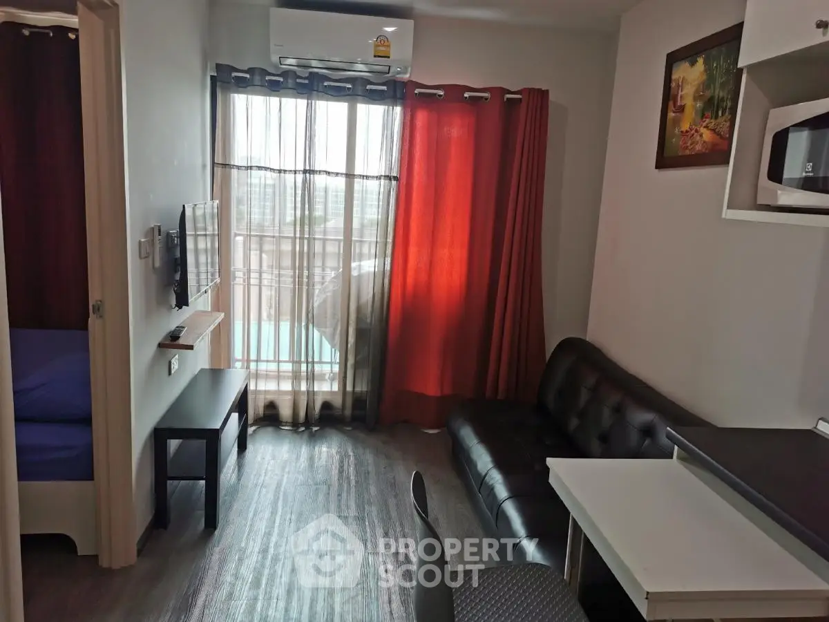 Modern living room with balcony, air conditioning, and stylish furniture in a cozy apartment.