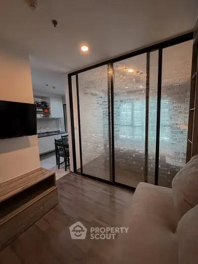 Modern living room with sliding glass partition and open kitchen layout