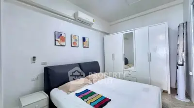 Cozy bedroom with modern decor and ample storage in a stylish apartment.