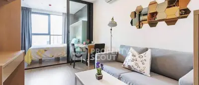 Modern living room with stylish decor and cozy bedroom in open layout apartment.