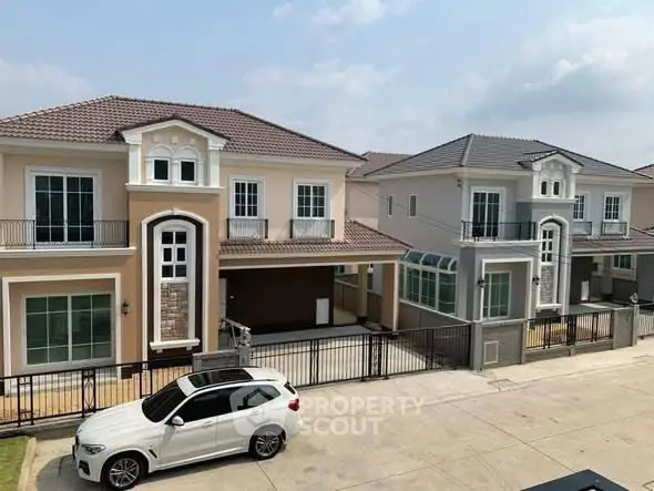 Elegant two-story houses with modern design and spacious driveway in a serene neighborhood.