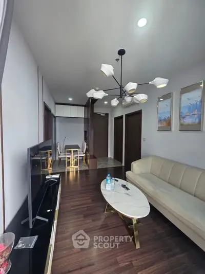 Elegant living room with modern chandelier and stylish furniture, perfect for contemporary living.