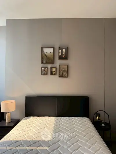 Modern bedroom with stylish decor and natural light, featuring a comfortable bed and elegant wall art.