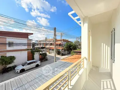Charming balcony view with clear blue skies and neighborhood houses, perfect for relaxing outdoors.