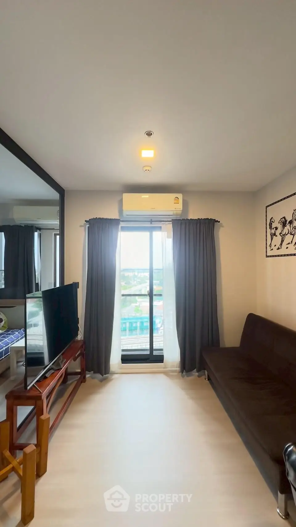 Modern living room with balcony view, featuring sleek furniture and natural light.