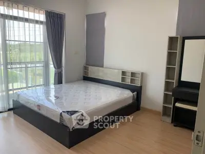 Modern bedroom with large window and stylish furniture, offering a bright and inviting atmosphere.