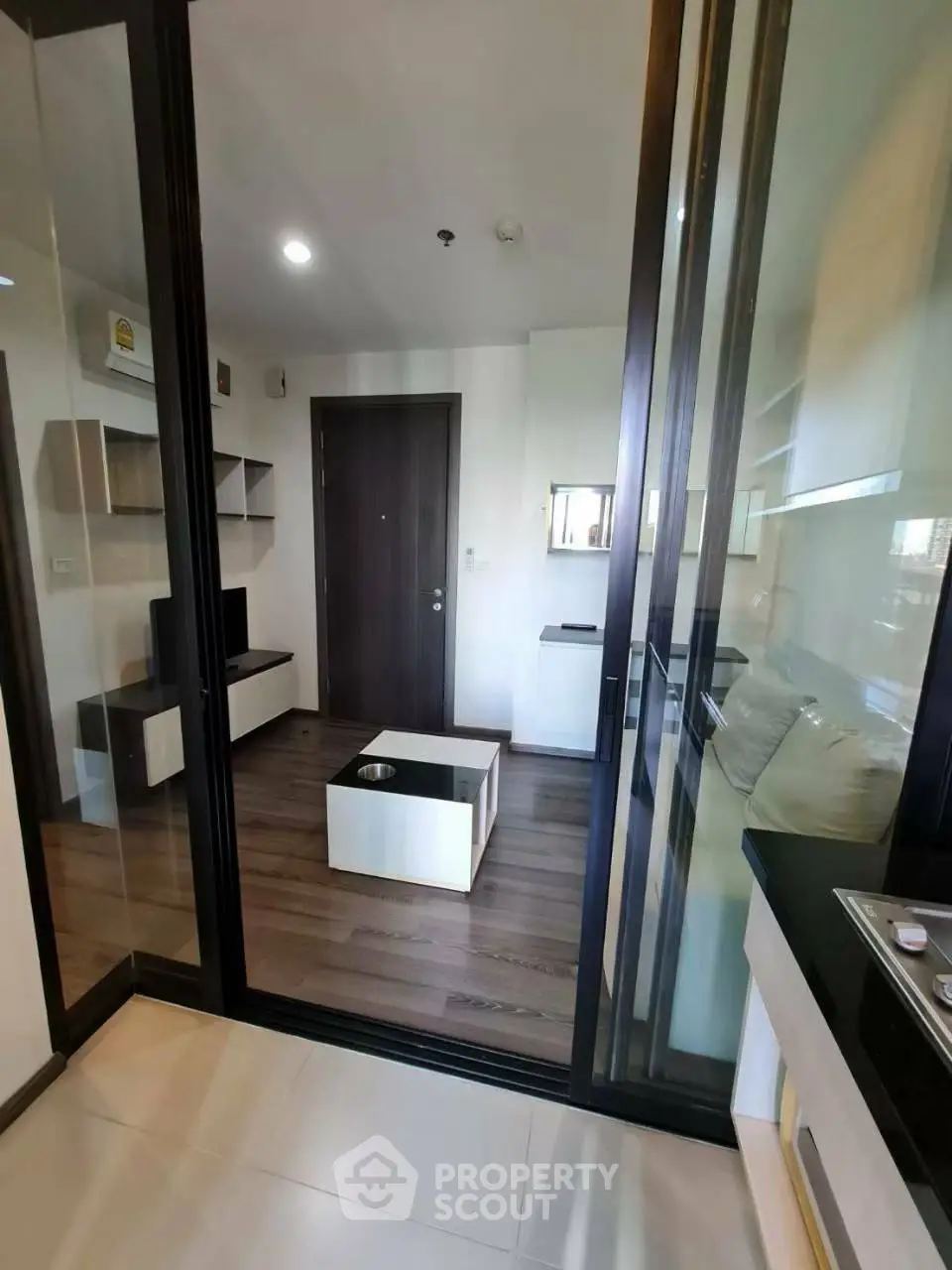 Modern living room with sleek glass doors and stylish wooden flooring