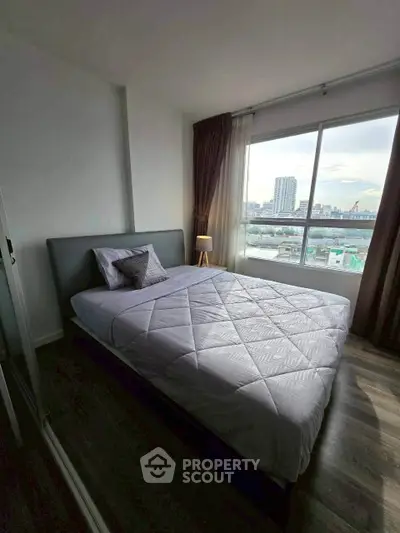Modern bedroom with large window offering stunning city view, featuring cozy bed and elegant decor.