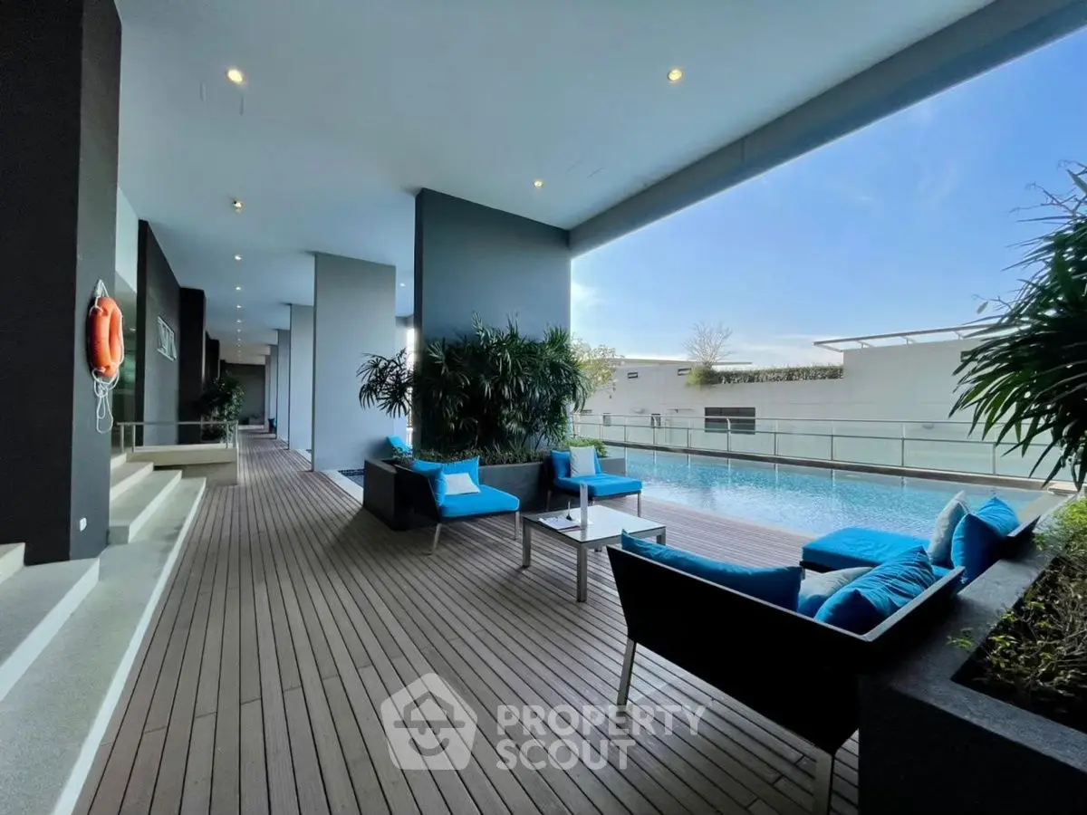 Luxurious poolside area with modern seating and stunning view, perfect for relaxation and entertainment.