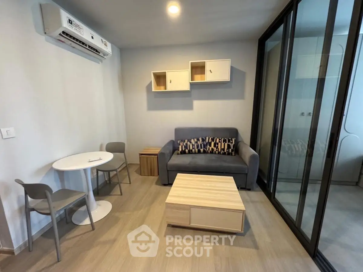 Modern living room with sleek furniture and glass partition, perfect for urban living.