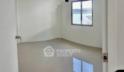 Spacious empty room with glossy tiled flooring and natural light