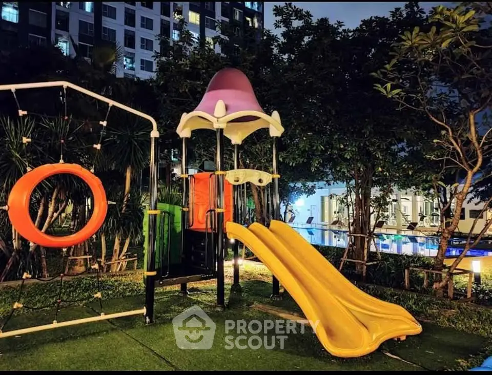 Modern apartment complex with vibrant playground at night, ideal for families seeking urban living.