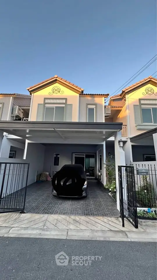 Charming two-story house with carport and gated entrance in a serene neighborhood.