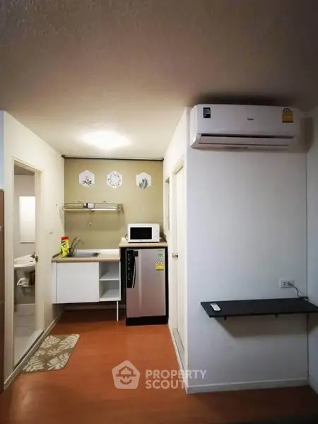 Compact kitchen with modern appliances and air conditioning in cozy apartment
