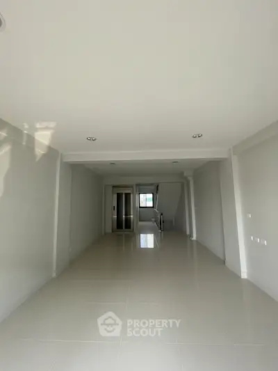 Spacious modern interior with sleek white tiles and elevator access