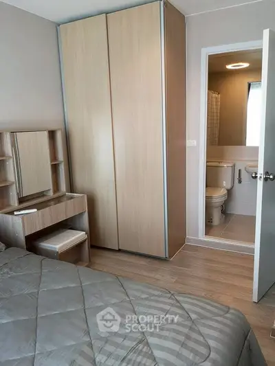 Cozy bedroom with ensuite bathroom featuring modern wooden furniture and neutral tones.