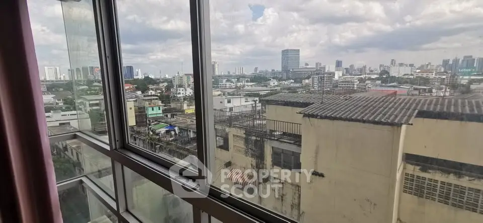 Stunning cityscape view from high-rise apartment window with expansive skyline.