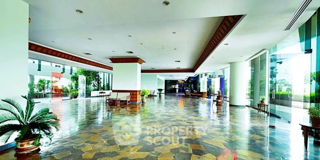 Spacious and elegant building entrance with modern design and lush greenery.