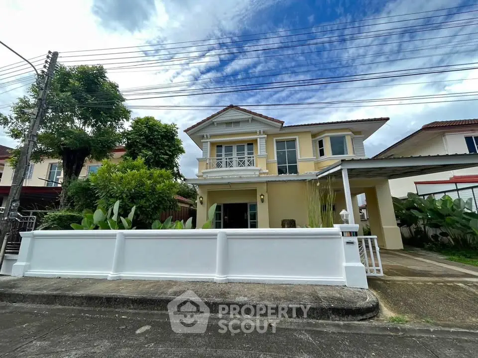 Charming two-story house with a lush garden and spacious driveway in a serene neighborhood.