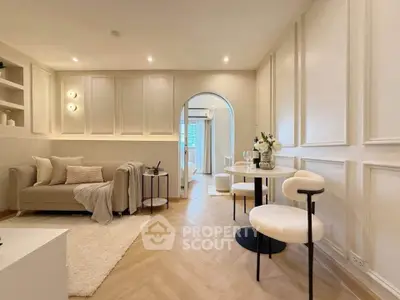 Elegant living room with modern decor and archway leading to another room, featuring cozy seating and stylish lighting.