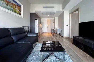 Modern living room with sleek black leather sofa and stylish decor in a contemporary apartment.