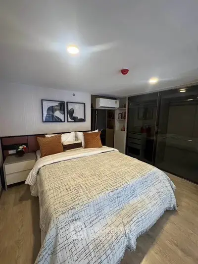 Modern bedroom with stylish decor and ample natural light, featuring a comfortable bed and sleek furnishings.