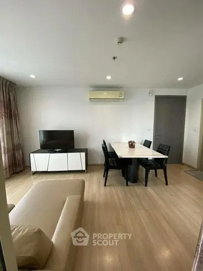 Spacious living room with modern furniture and dining area in a stylish apartment.