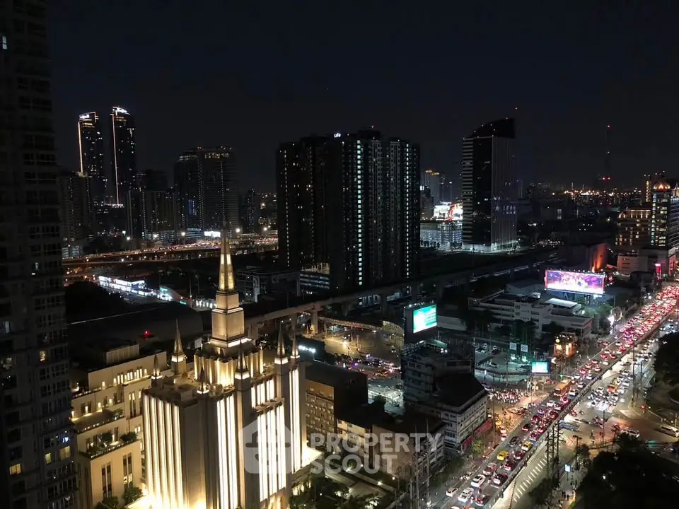Stunning cityscape view from high-rise building at night with vibrant lights and bustling streets.