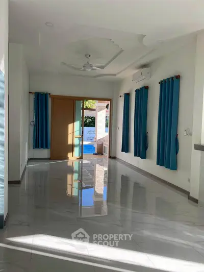 Spacious living room with modern design and large windows offering natural light.