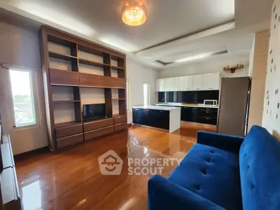 Spacious open-plan living room with modern kitchen and elegant wooden flooring.