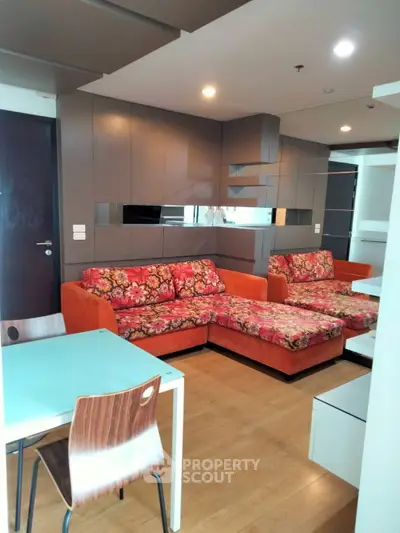 Modern living room with vibrant floral sofas and sleek design