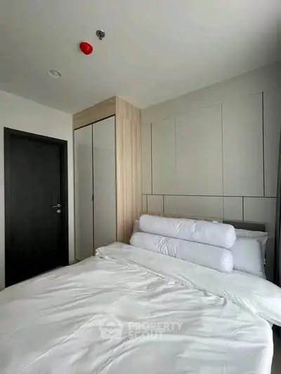 Modern bedroom with sleek design and cozy bedding in a contemporary apartment.