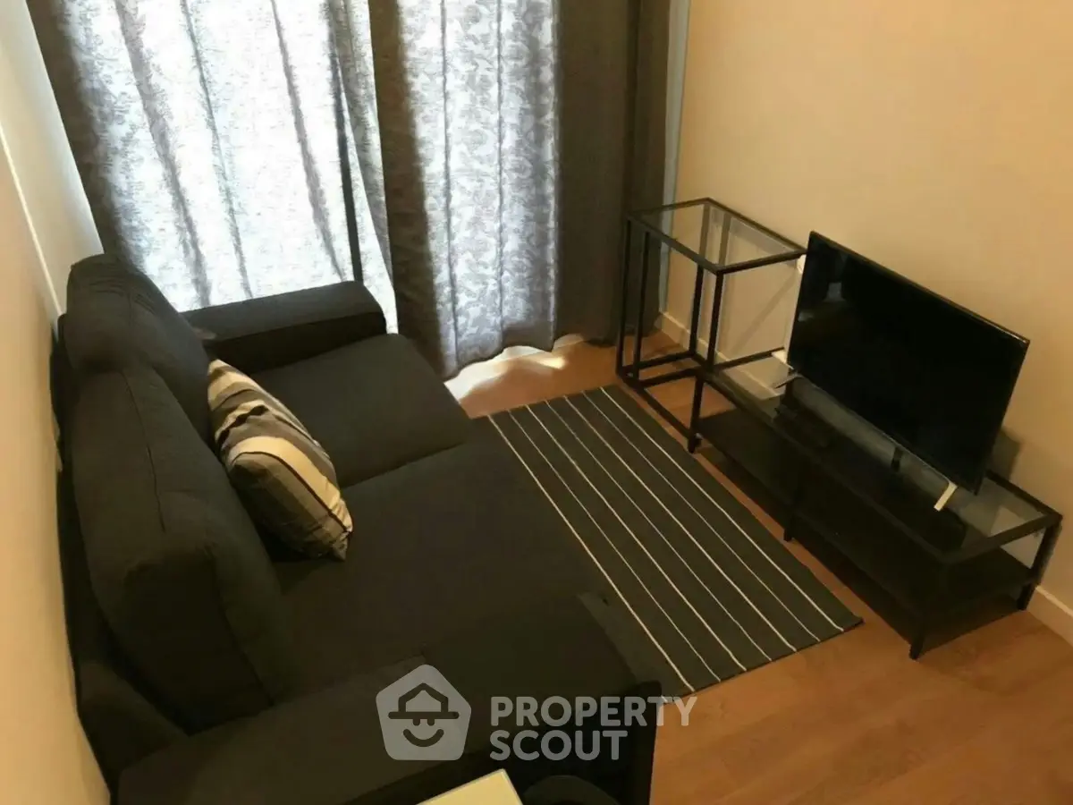 Cozy living room with modern sofa and TV setup, perfect for relaxation.