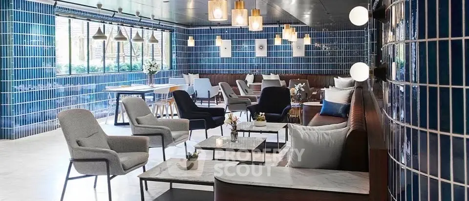 Stylish modern lounge with blue tiled walls and elegant seating, perfect for relaxation or meetings.