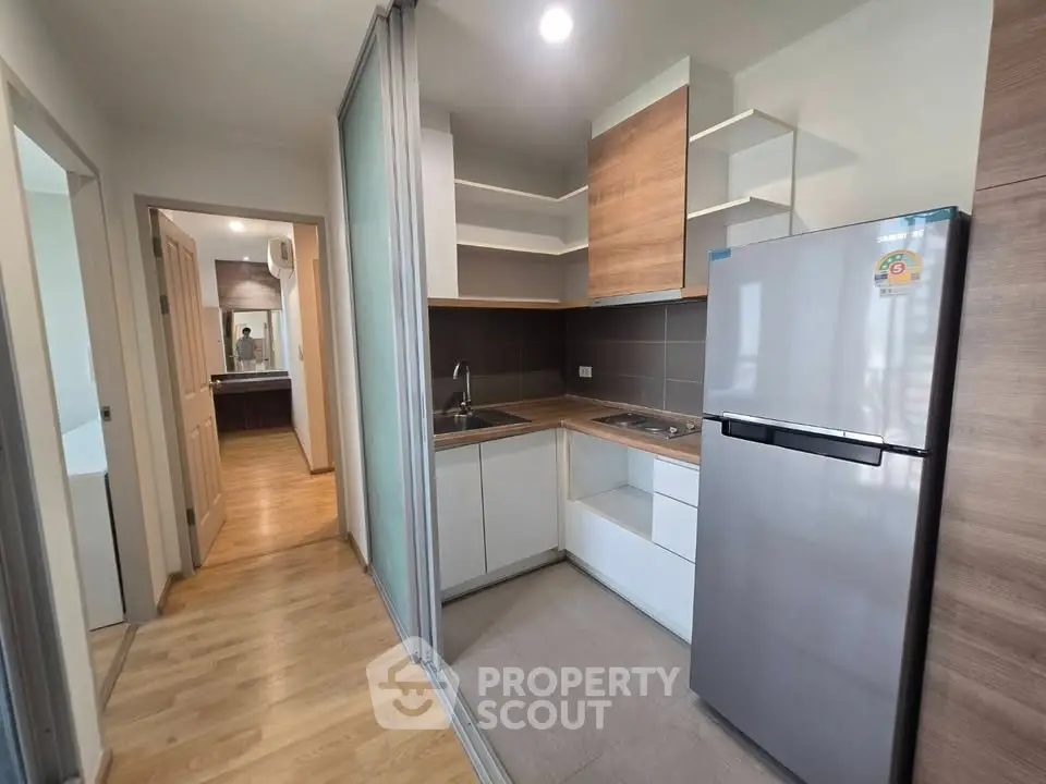 Modern kitchen with sleek design and stainless steel fridge in a cozy apartment.
