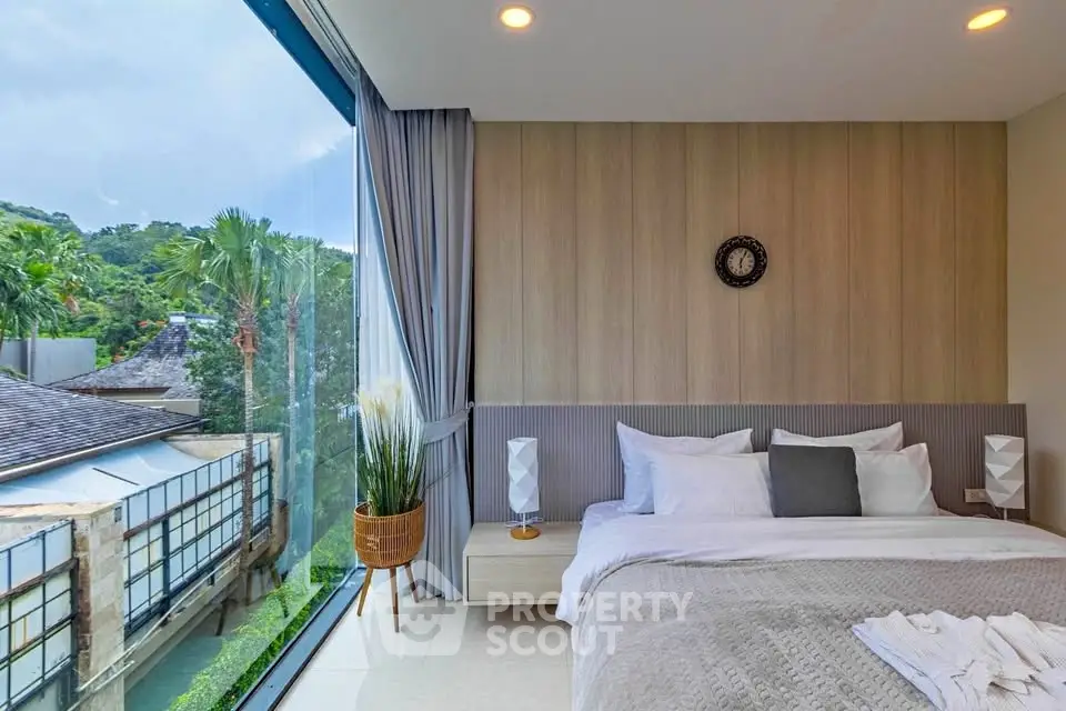 Luxurious bedroom with large window offering stunning garden view