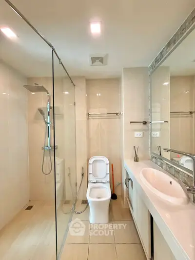 Modern bathroom with glass shower and sleek fixtures in a contemporary home.