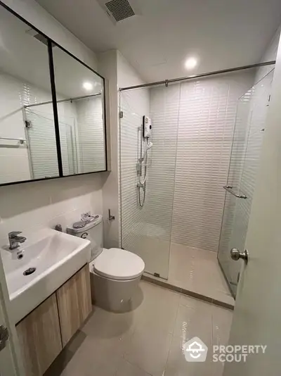 Modern bathroom with glass shower and sleek vanity in contemporary apartment