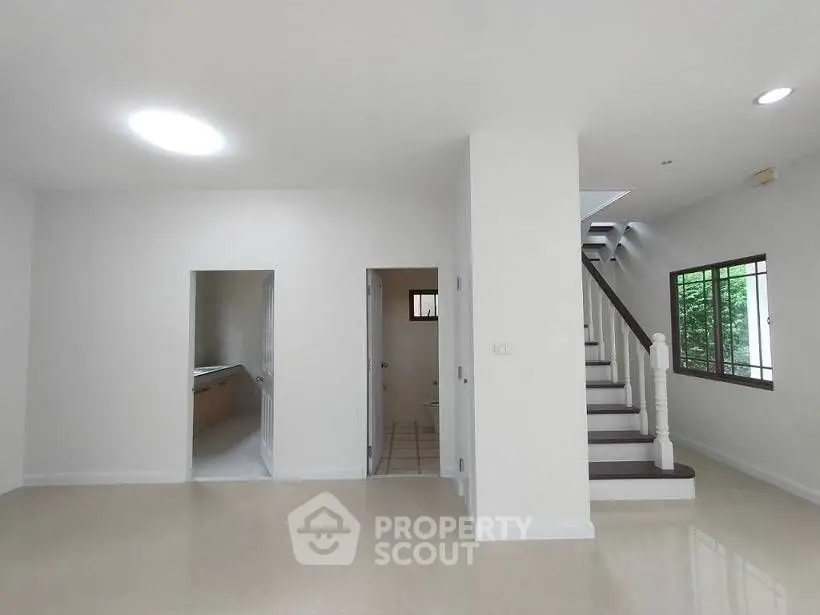 Spacious modern interior with staircase and natural light, ideal for stylish living.