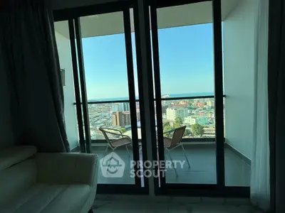 Stunning high-rise balcony with panoramic city view and cozy seating area.