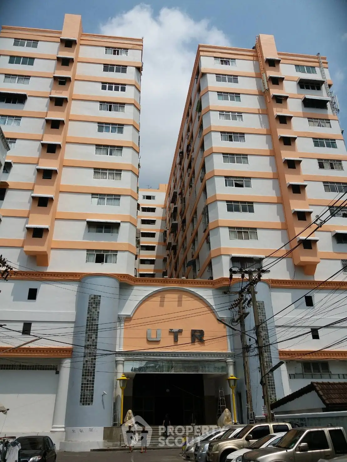 Impressive multi-story residential building with modern architecture and ample parking space.