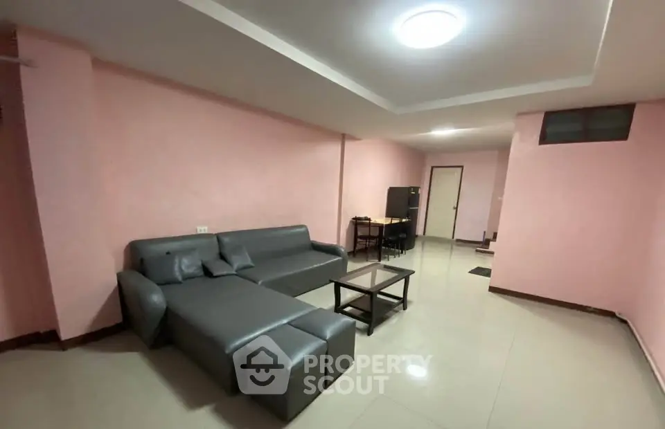 Spacious living room with modern gray sofa and sleek coffee table in a cozy apartment.