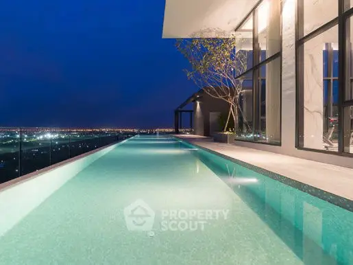 Luxurious rooftop infinity pool with stunning city skyline view at night.