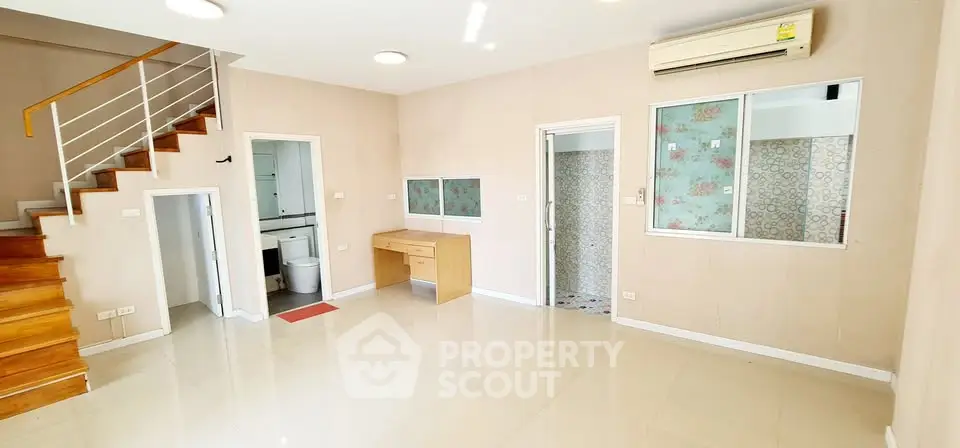Spacious open-plan living area with modern staircase and air conditioning