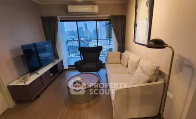 Modern living room with city view, stylish furniture, and large windows in a high-rise apartment.
